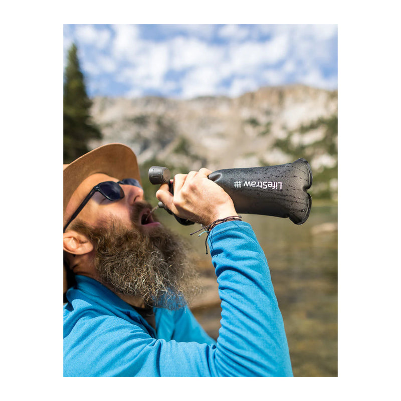 Mountain Blue | LifeStraw Peak Collapsible Squeeze Bottle  650ml Image Showing Model Drinking From Bottle.