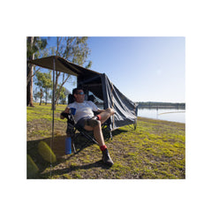 Black | Oztrail Blockout Easy Fold Stretcher Tent - Single. Shown In Use By The Lake. 