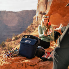 Navy / 6L | YETI Daytrip Insulated Luch Bag Image Showing Lunch Bag Being Used On A Hiking Trip.