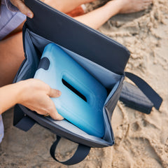 Navy / 14L | YETI Daytrip Insulated Tote Bag Image Showing A YETI_ICE SHEET Being Pout Into The Tote Bag At The Beach.