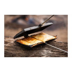 Black / Double | Campfire Double Jumbo Jaffle Iron Image Showing Iron Sitting On A Log Being Open After Cooking To Remove The Jaffles.
