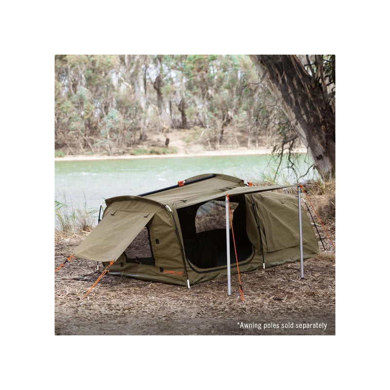 1400 / Khaki | Darche Dirty Dee Swag With 70mm Mattress Image Showing The Swag Set Up Under A Tree, Next To A River.