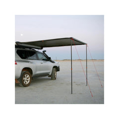 2.5m x 2.5m | Darche Eclipse Slimline Awning Image Showing Side View Of Awning Set Up On A Beach A Dusk.