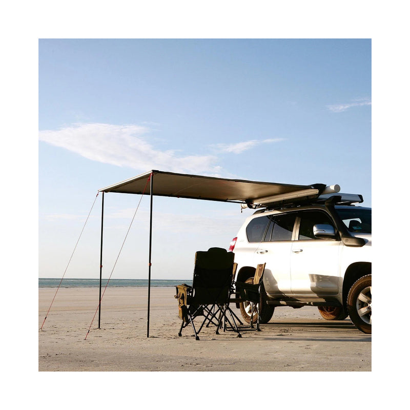 2.5m x 2.5 | Darche Eclipse Slimline Awning Image Showing Angled View Of The Awning Set Up With Camp Chairs Under The Awning ON A Beach.