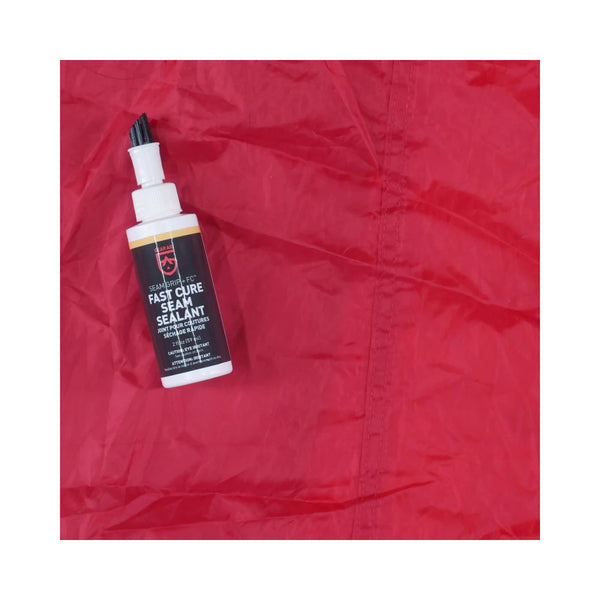 Gear Aid Seam Grip + FC Tent Sealant | Image Showing Sealant Bottle On The Fabric Next To Where It Had Been Applied.