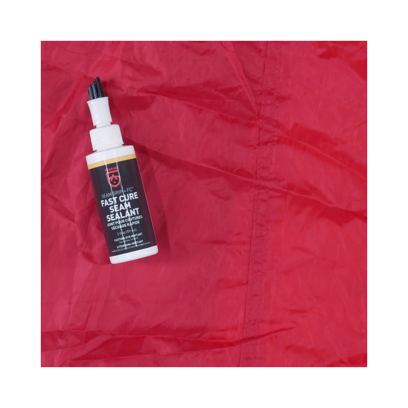 Gear Aid Seam Grip + FC Tent Sealant | Image Showing Sealant Bottle On The Fabric Next To Where It Had Been Applied.
