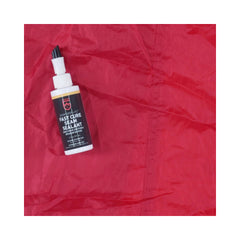 Gear Aid Seam Grip + FC Tent Sealant | Image Showing Sealant Bottle On The Fabric Next To Where It Had Been Applied.