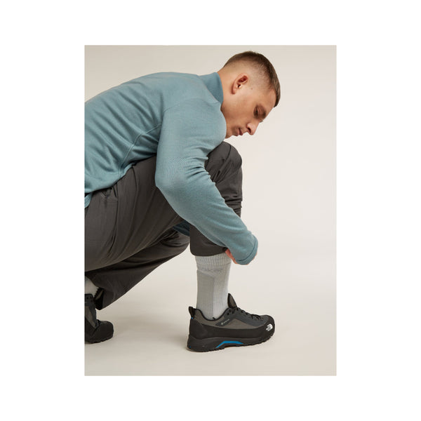 Grey | Icebreaker Men's Merino Hike + Crew Socks Image Showing Male Model Putting On Hiking Shoes While Wearing The Crew Socks.