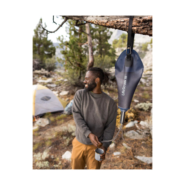 Mountain Blue | LifeStraw Peak Compact Gravity Water Filter System 3L Image Showing System Hung In A Tree Filling A Cup With Water.