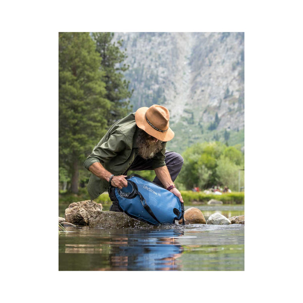 Mountain Blue/8L |LifeStraw Peak Series Gravity Water Filter System Image Showing The Water System Being Filled In A Stream.