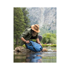 Mountain Blue/8L |LifeStraw Peak Series Gravity Water Filter System Image Showing The Water System Being Filled In A Stream.