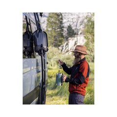 Mountain Blue/8L | LifeStraw Peak Series Gravity Water Filter System Image Showing Poured Into A Cup At Camp.