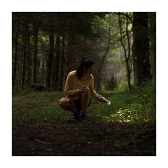 Luci-Solar HeadLamp And FlashLight | Image Showing Women Using The Flash Light, Connected To The Solar Charger Battery,  To Look Into The Grass.