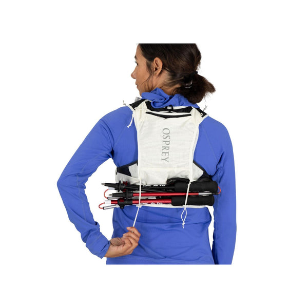 Mystery White | Osprey Duro Pro 10L Womens Hydration Vest With Flasks Image Showing The Osprey Duro Pro 10L Womens Hydration Vest With Flasks  On A Model Image Showing Back View With Walking Poles Attached Across The Bottom Of The Vest.