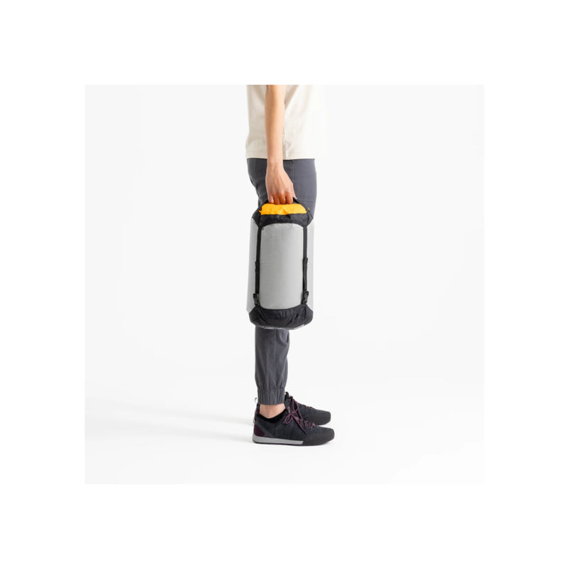 High Rise / 13L | Sea To Summit Evac Ultra-Light Compression Dry Bag Image Showing A Male Model Carrying The Dry Bag.