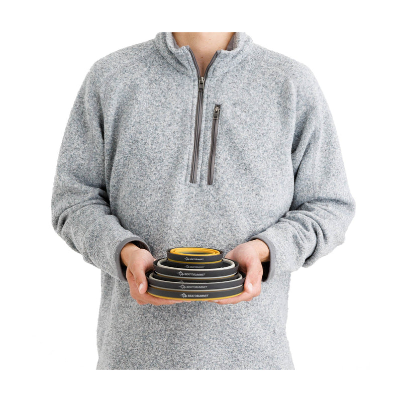 6 Piece | Sea To Summit Frontier Ultralight Collapsible Dinnerware Set Image Showing Dinnerware Packed Down In A Model's Hands.