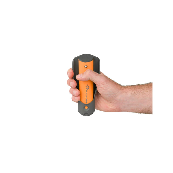 Grey / Orange | Sea To Summit Pocket Trowel Image Showing Trowel Packed Down For Travel Ad Storage, In A Hand To Show The Size Of The Pocket Trowel.