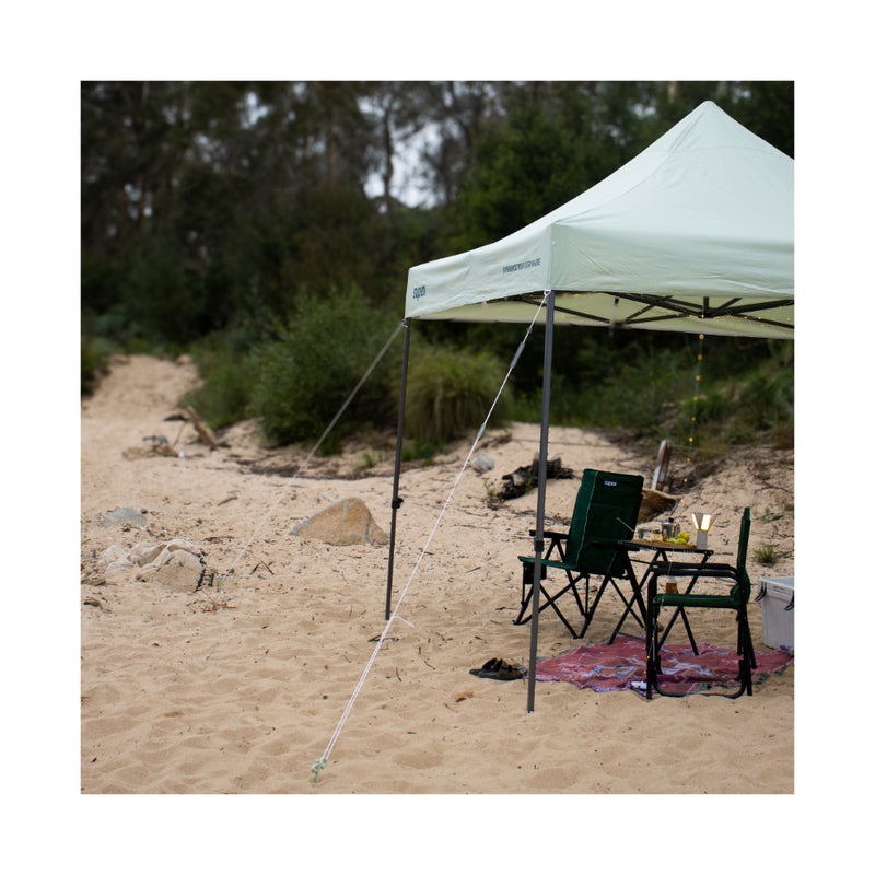 3 x 3 | Supex Gazebo Image Showing The Gazebo Set Up At The Beach With The Tie Downs, Pegged Down In The Sand.
