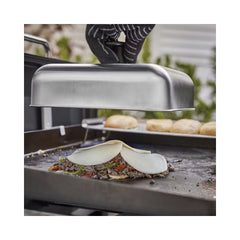 Stainless Steel | Weber Basting Dome Image Showing Dome Being Placed Over Food On A Weber BBQ Hot Plate.