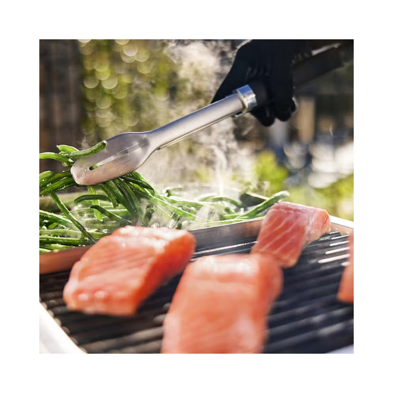 Black | Weber Lumin Electric BBQ With Stand And Side Table Image Showing Close Up View Of, Grill Plate With Fish Cooking And Green Beans Steaming.