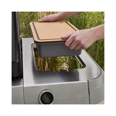 Weber Works Basin With Cutting Board Lid | Image Showing Basin Being Placed Into The BBQ Stand.
