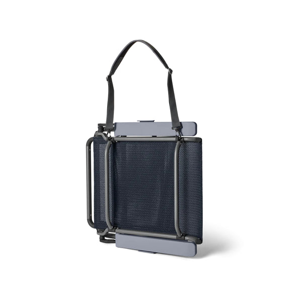 Navy | YETI Hondo Beach Chair Image Showing Angle View Of The Beach Chair Folded Up With Carry Strap.