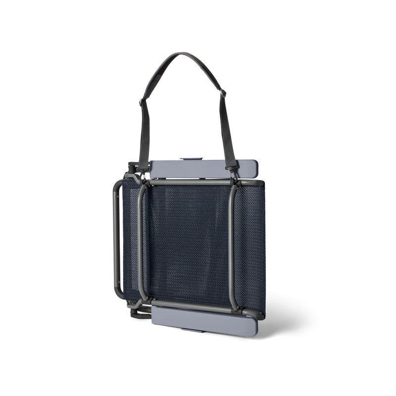 Navy | YETI Hondo Beach Chair Image Showing Angle View Of The Beach Chair Folded Up With Carry Strap.