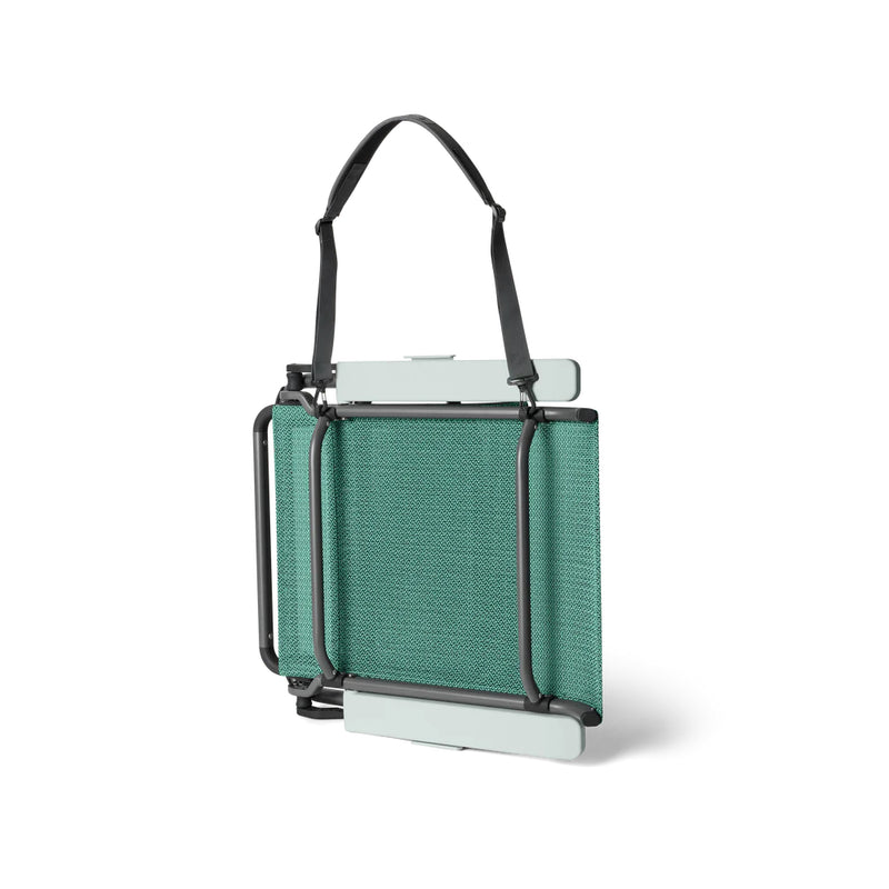 Seafoam | YETI Hondo Beach Chair Image Showing Side View Of The Chair Folded Down, With Carry Strap Attached.