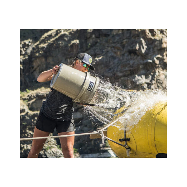 Tan | YETI Loadout Bucket Image Showing A Model Using The Bucket The Throw Water On A Inflatable Boat.