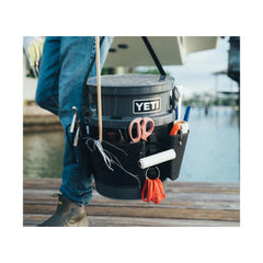 Black | YETI Loadout Bucket Utility Gear Belt  Image Showing A Model Using The Gear Belt To Help Carry Small Fishing Accessorises, On A YETI Loadout Bucket (Sold Separately) To Help Keep His Hands Free.