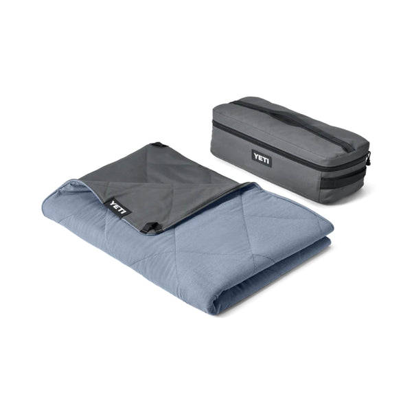Smoke Blue | YETI Lowlands Blanket. Shown Folded up Next to Storage Bag. 