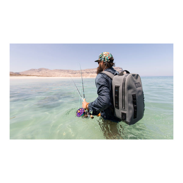 Charcoal | YETI Panga Submersible Backpack - 28L. Shown on Model While Fishing.