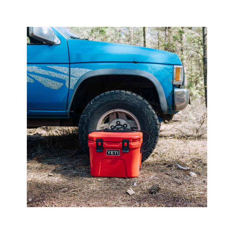 Rescue Red | YETI Roadie 15 Hard Cooler Image Showing The Cooler Next To A truck In The Bush.