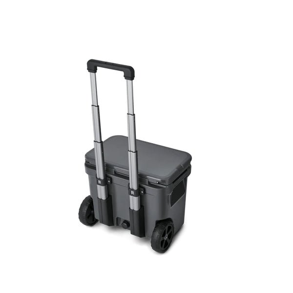 Charcoal | YETI Roadie 32 Wheeled Hard Cooler Image Showing Angled Back View Handle Up Lid Down.