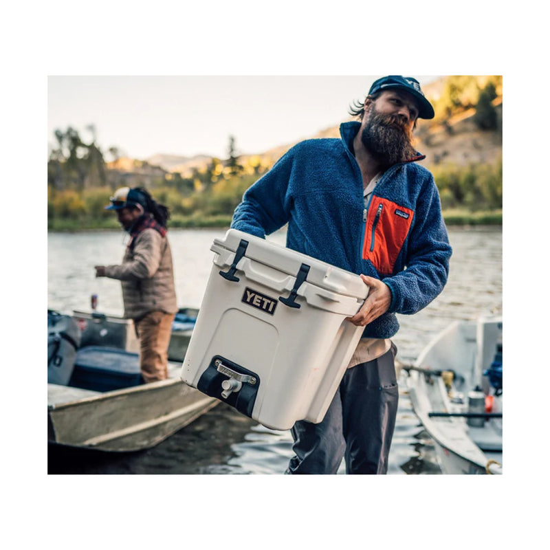 White | YETI Silo 22.7 Water Cooler With Tap Image Showing Cooler Being Carried Off of A Boat.