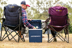 Blue and White | Companion Hard Cooler 26L. Lifestyle image of couple on camp chairs with cooler getting out a can