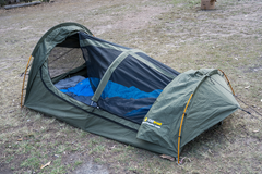 Swag set up on grass area with sleeping bag inside and access open