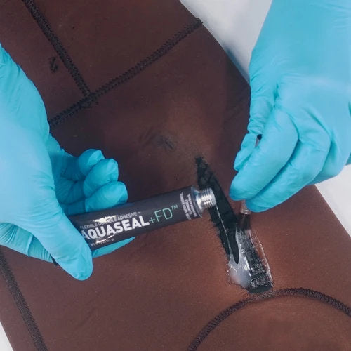 Applying Gear Aid Aquaseal FD Repair Adhesive to wetsuit tear