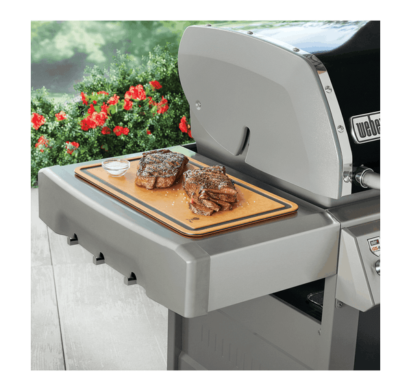 Cutting board being used on the side table of a hooded gas bbq