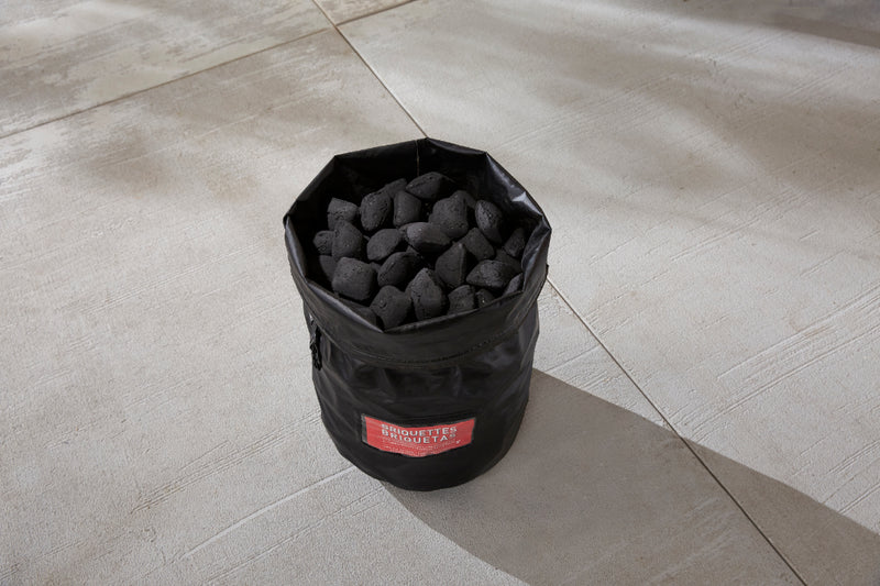 Bag with top rolled showing full of charcoal