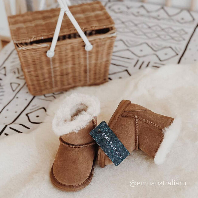 Chestnut | Styled image of slippers on sheepskin rug with cane basket in the background