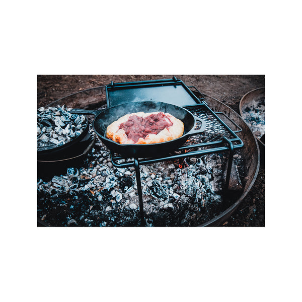 Side View of Skillet cooking Berry Pie on Campfire. 
