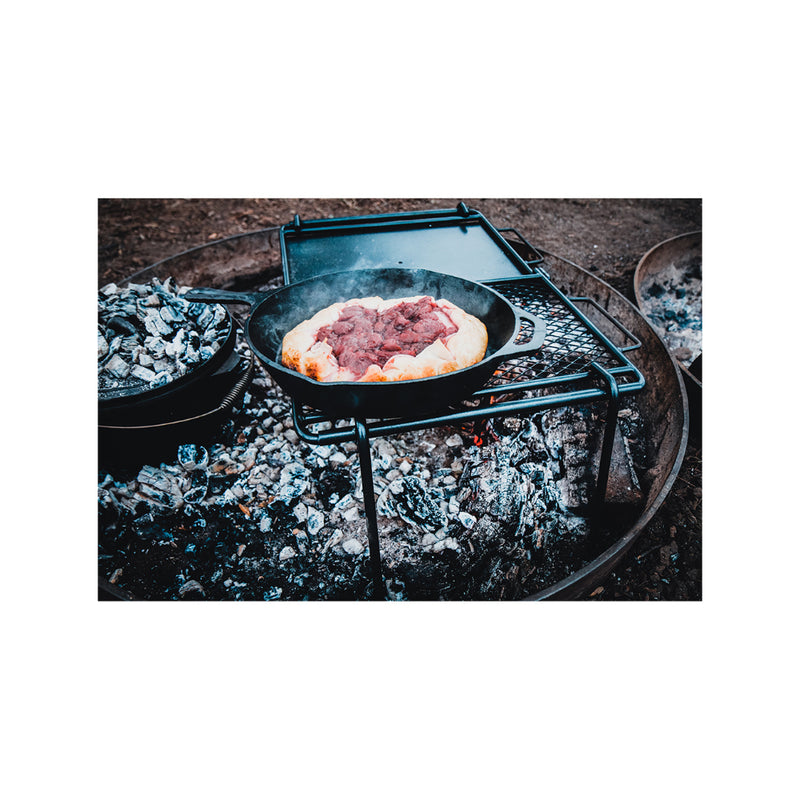 Side View of Skillet cooking Berry Pie on Campfire. 