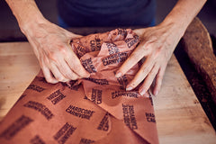 Someone wrapping meat inside paper