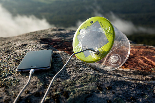 Inflated lantern with phone charging on a rock