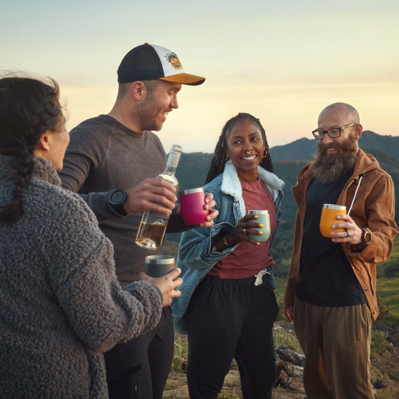 Orchid | picture of a group of 4 people standing outside with tumblers sharing a bottle of wine