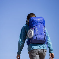 Deflated Lantern hanging on side of backpack charging with solar while hiking