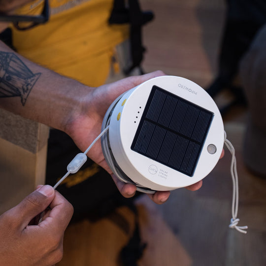 Multi | Light string being unwrapped from base. Solar panel visible.