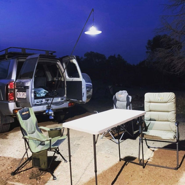 Light mounted on back of 4WD lighting up campsite at dusk