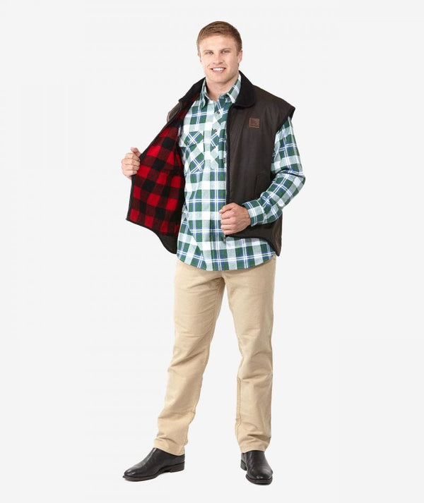 Brown | Swanndri Mens Foxton Wool Lined Oilskin Vest. holding the unzipped front open to expose the red and black checked wool lining